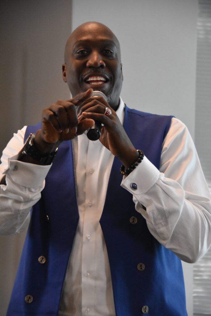 Mark Wiggins speaking on stage holding a microphone.